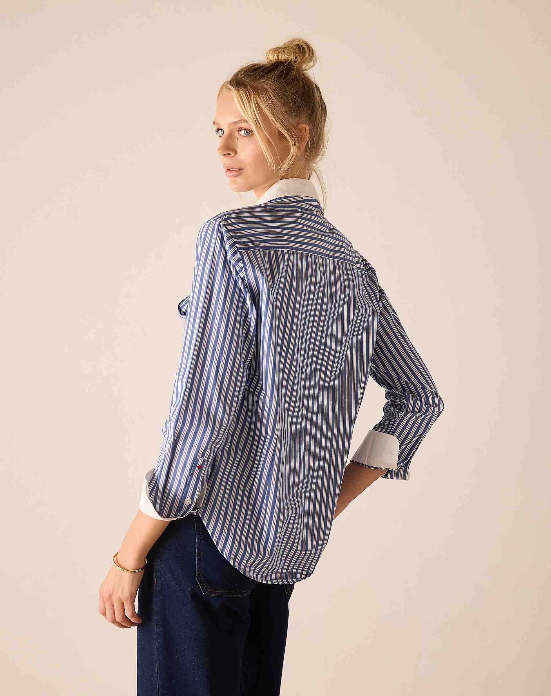 Blue and white double stripe button-up shirt with rolled sleeves.