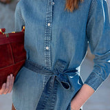 Medium blue button-up chambray shirt with a waist tie detail.