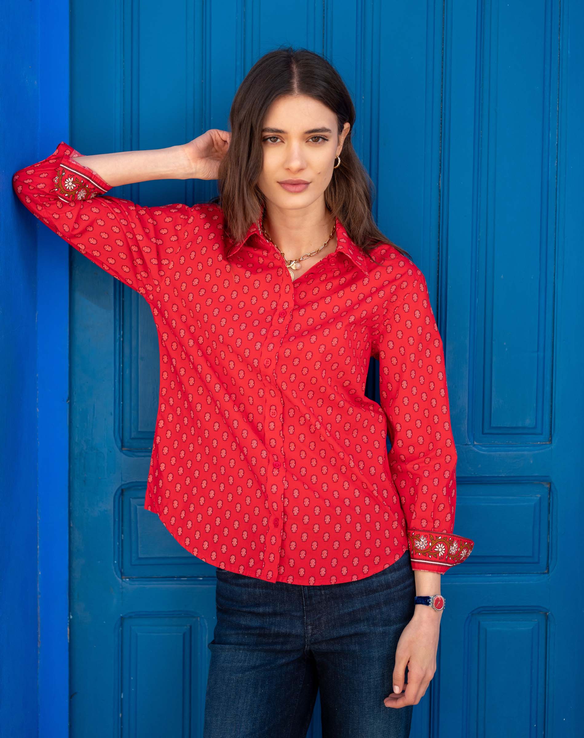 Crimson red button-up shirt with a small repeating dot pattern and embroidered details on the cuffs.