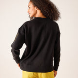 Back view of a black sweatshirt featuring an embroidered detail on the sleeve.