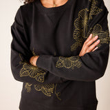 Military green relaxed-fit knit sweatshirt with yellow embroidered daisy details.