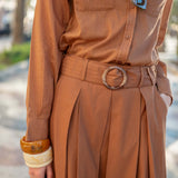 Saddle-colored pleated skirt with a high waist and matching belt.