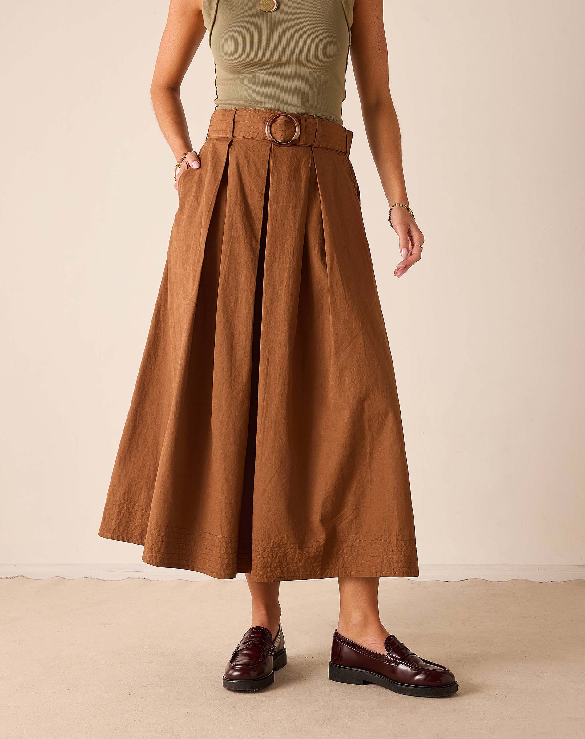 Saddle brown high-waisted pleated midi skirt with a belt and center seam.