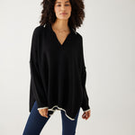 woman showcasing mersea marina polo sweater in black with sand color detail