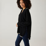 profile of woman showcasing mersea marina polo sweater in black with sand color detail