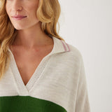 closeup of woman showcasing mersea marina polo sweater in green and sea salt stripe