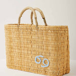 Market straw basket with tan leather handles and Cancer symbol embroidered in light blue