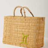 Market straw basket with tan leather handles and Gemini symbol embroidered in green