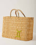 Market straw basket with tan leather handles and Gemini symbol embroidered in green