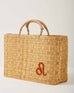 Market straw basket with tan leather handles and Leo symbol embroidered in burnt orange