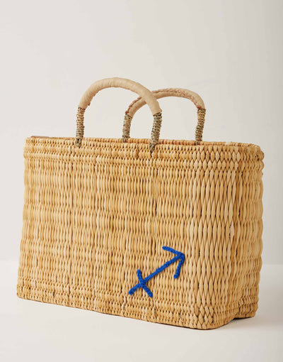 Market straw basket with tan leather handles and Sagittarius symbol embroidered in blue