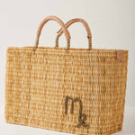 Market straw basket with tan leather handles and Virgo symbol embroidered in brown