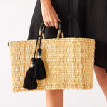 woman holding medina basket with black tassel