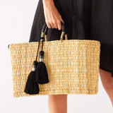 woman holding medina basket with black tassel