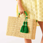 woman holding medina tassel basket with green tassel