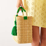 woman holding medina basekt with green tassel