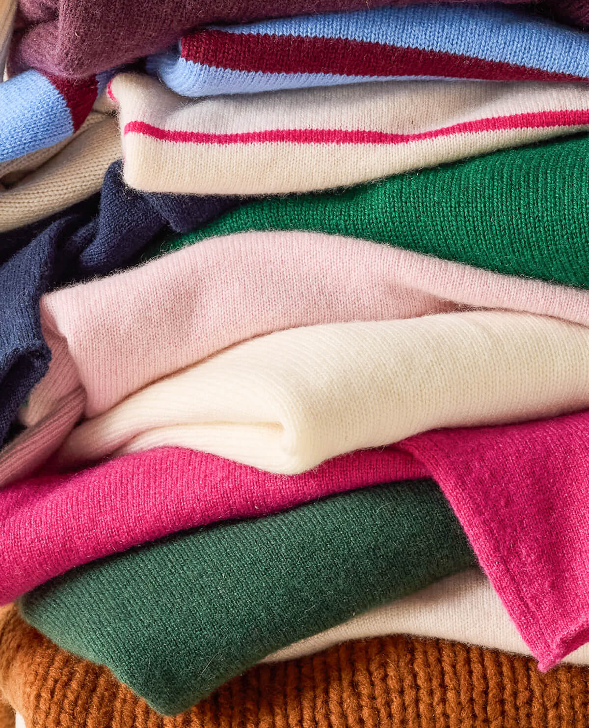 Stack of colorful sweaters in various colors
