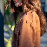 Saddle brown cotton button-up shirt featuring double pockets and a relaxed fit.