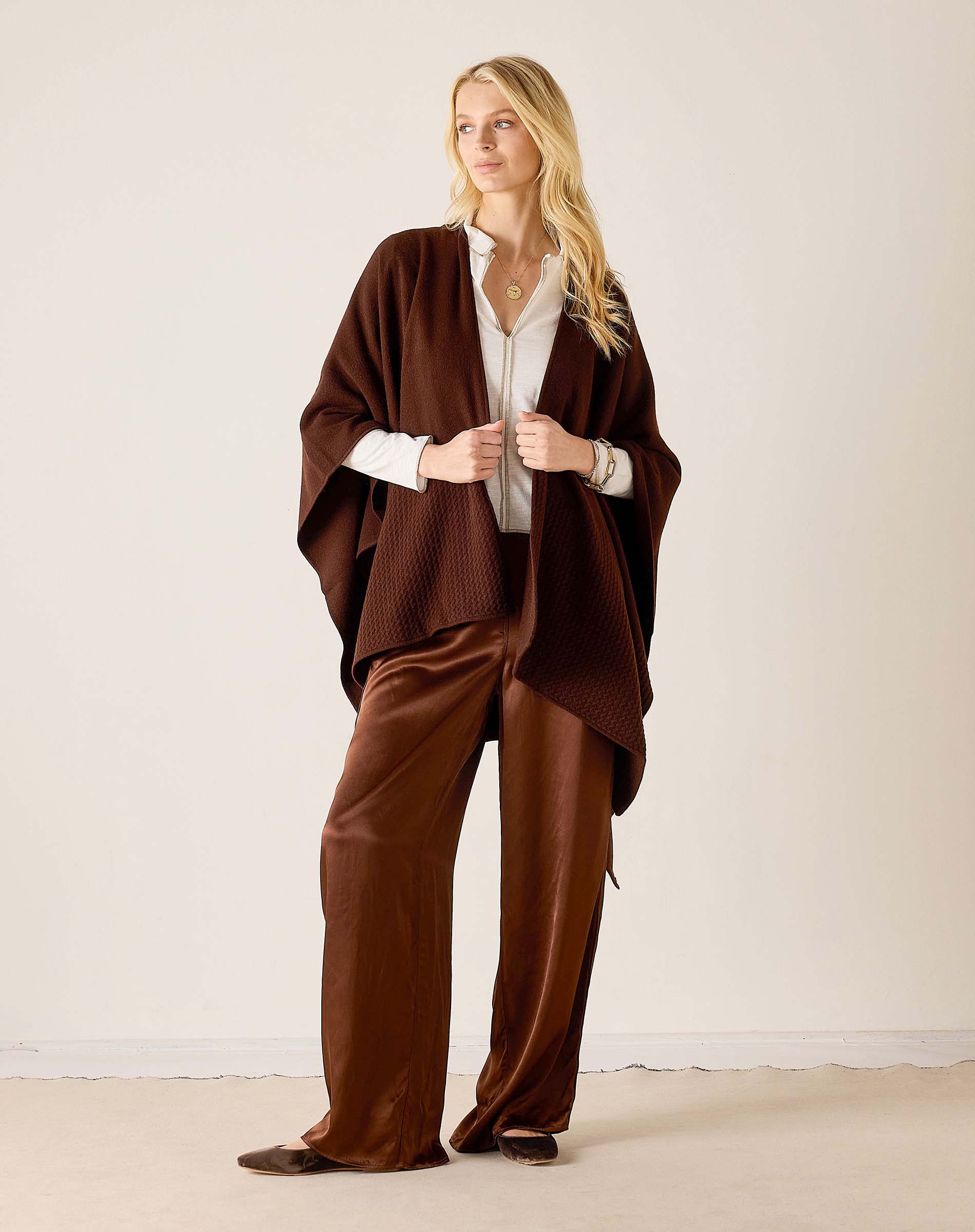 MERSEA ladies' travel-ready women's travel-friendly chocolate ribbed knit travel wrap worn over a light-colored button-down shirt and wide-leg trousers.