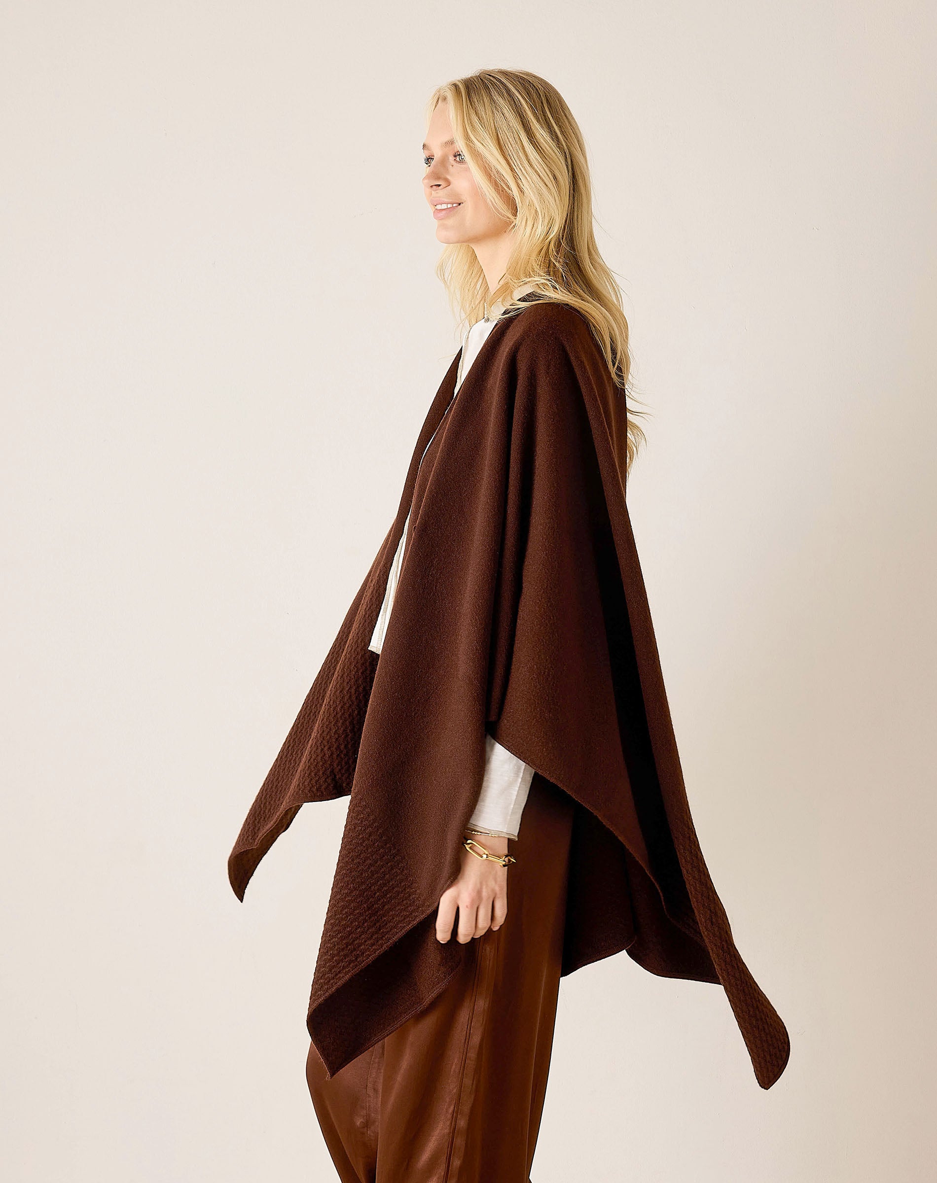 Side view of the chocolate-colored knit travel wrap with a draped silhouette.