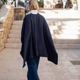 Ladies' travel-ready back view of the navy textured knit travel wrap over a white collar and dark denim jeans.