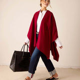 Wine-colored knit travel wrap featuring a draped silhouette and voluminous folds.