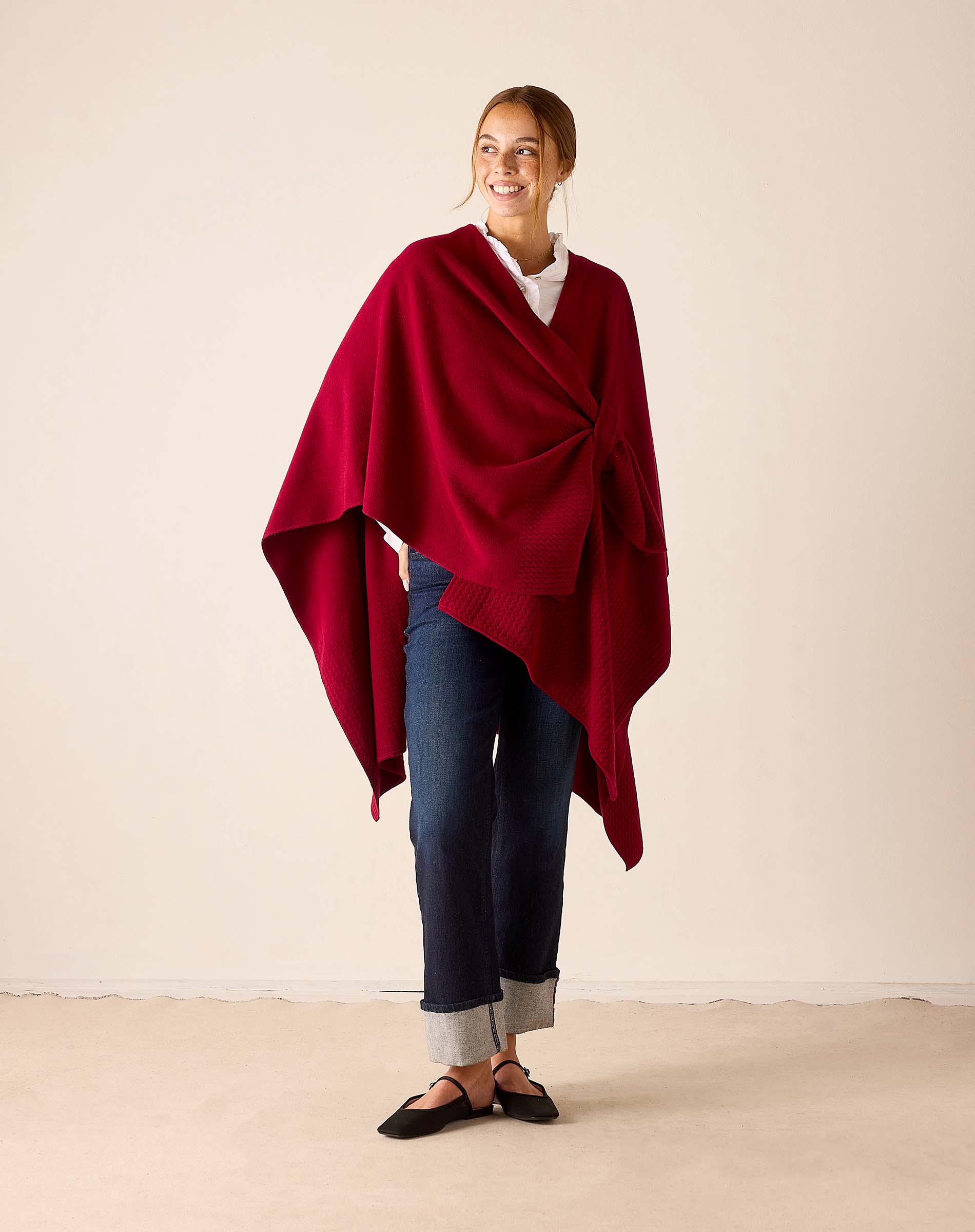 Wine-colored knit travel wrap with a draped silhouette and wide hem.
