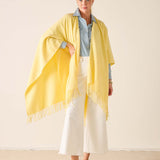 Woman wearing a yellow scarf with a plain background