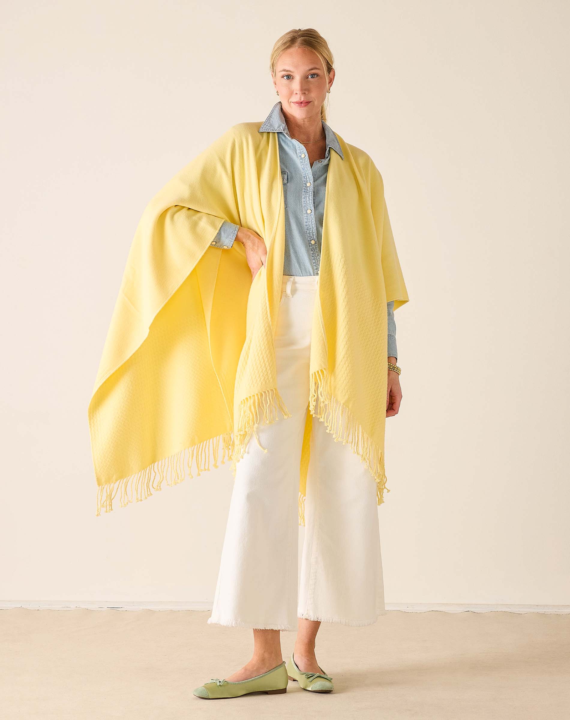 Woman wearing a yellow scarf with a plain background