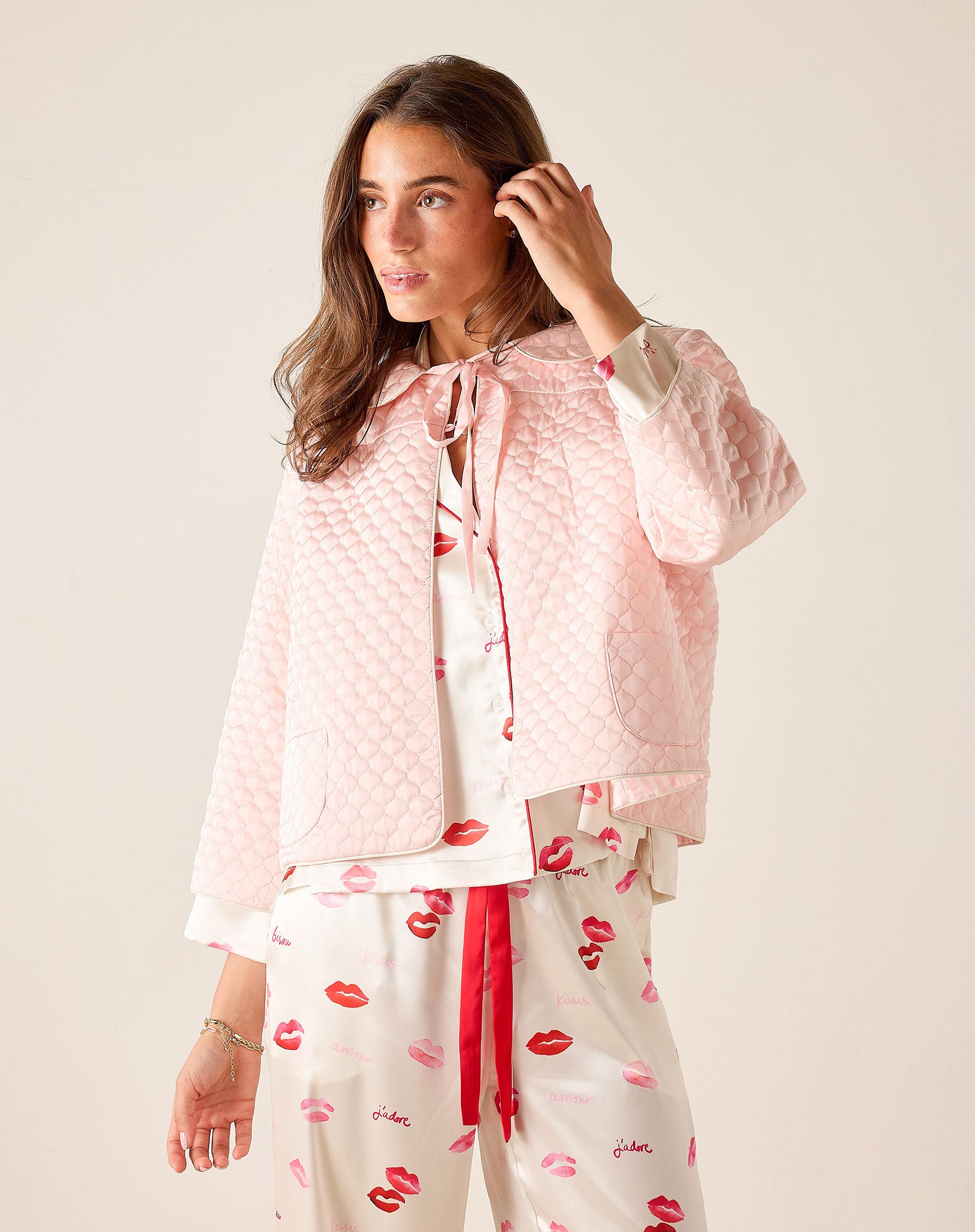 Woman wearing a pink patterned outfit with a plain background