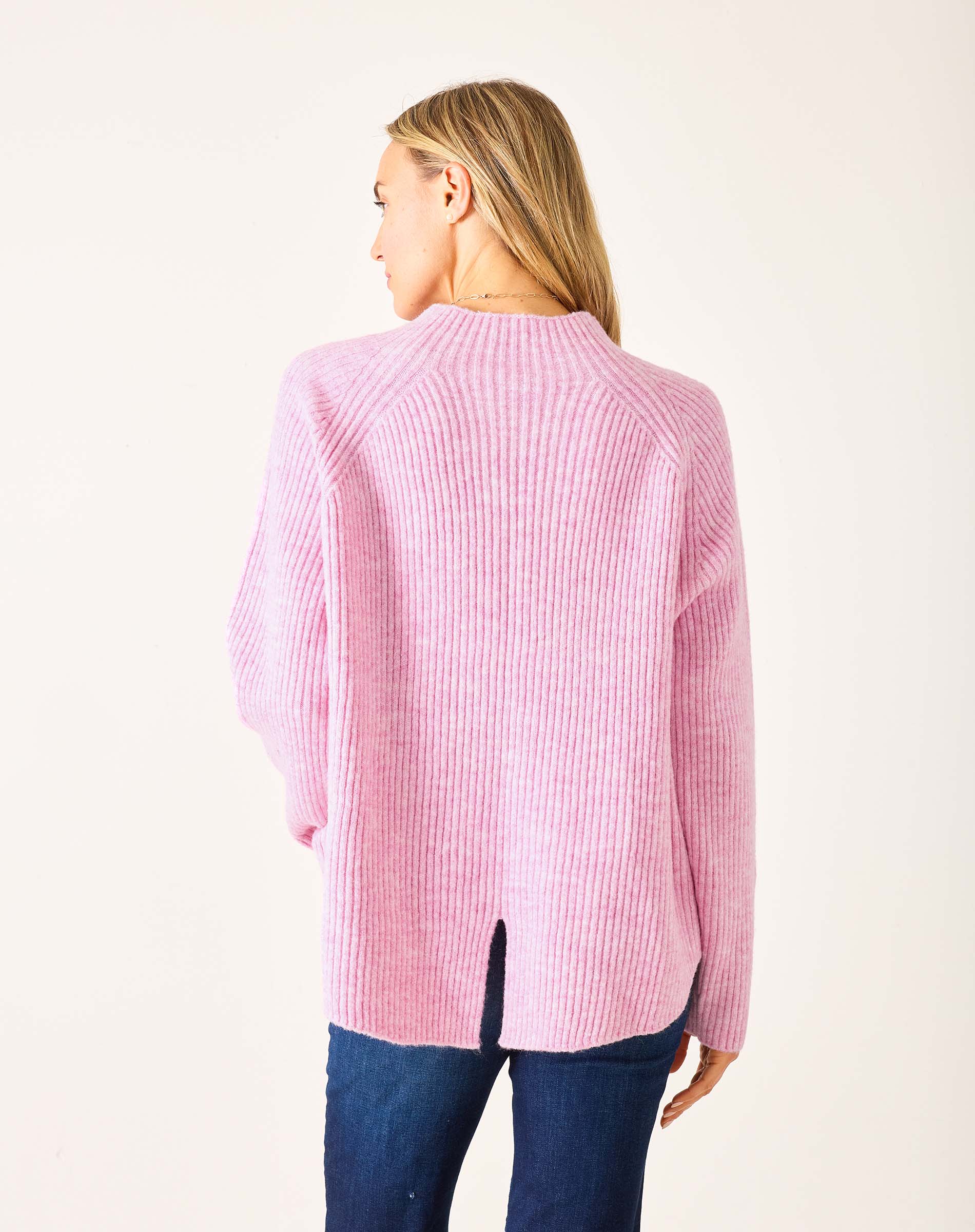 Back view of women's travel-friendly heathered dewy pink mockneck ribbed sweater with center back slit