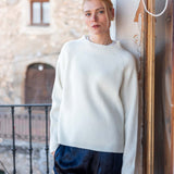 Winter white ribbed knit sweater with long sleeves and a crew neck.