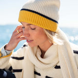 Cream and golden yellow ribbed knit beanie with a large faux fur pom-pom.