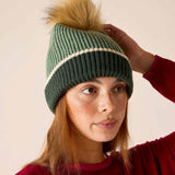 Sage green knit beanie with cream stripe and tan pom-pom.