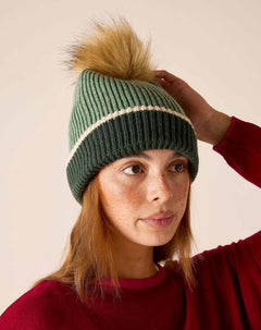 Sage green knit beanie with cream stripe and tan pom-pom.