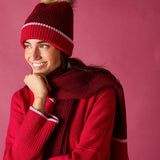 Raspberry pink ribbed knit beanie with a plush faux fur pom-pom.