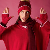 Raspberry pink knit beanie with white polka dot trim and faux fur pom-pom.