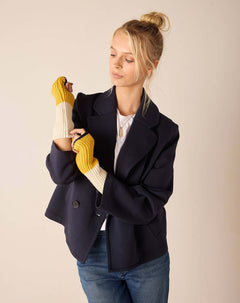 Cream and golden yellow knit fingerless gloves with ribbed cuffs.