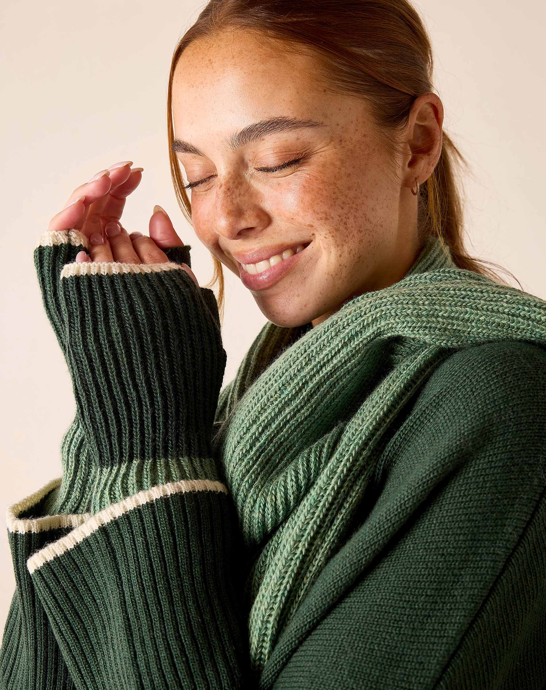 Sage green ribbed knit sweater with white stripe detailing and fingerless gloves.