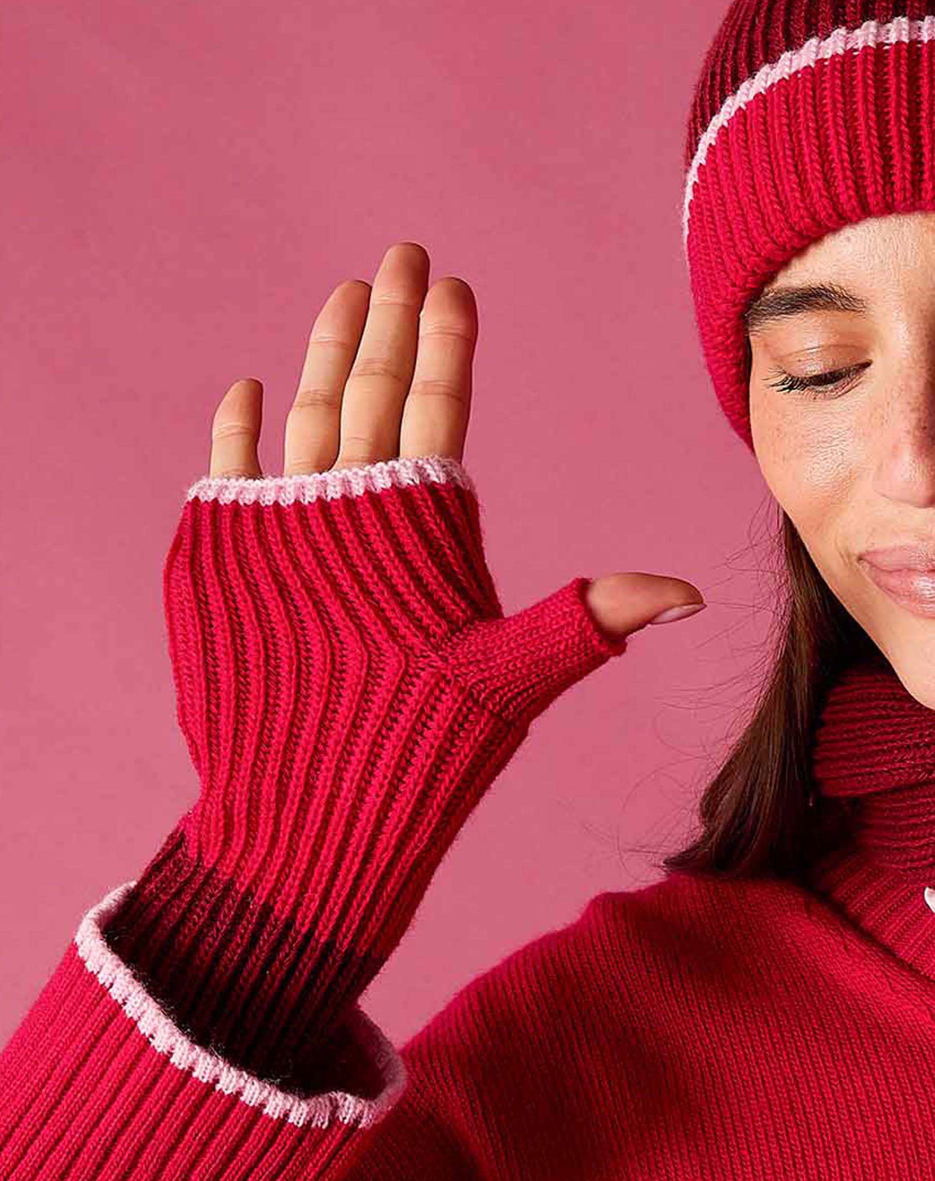 Raspberry pink ribbed knit fingerless gloves with a white stripe detail.