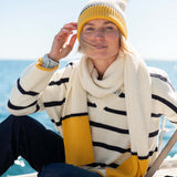 Cream and golden yellow striped knit scarf with oversized fringe.