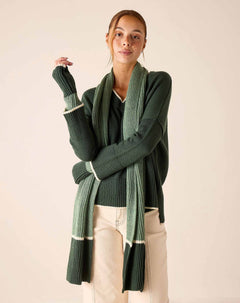 Forest green and cream striped ribbed knit scarf draped over a sweater.