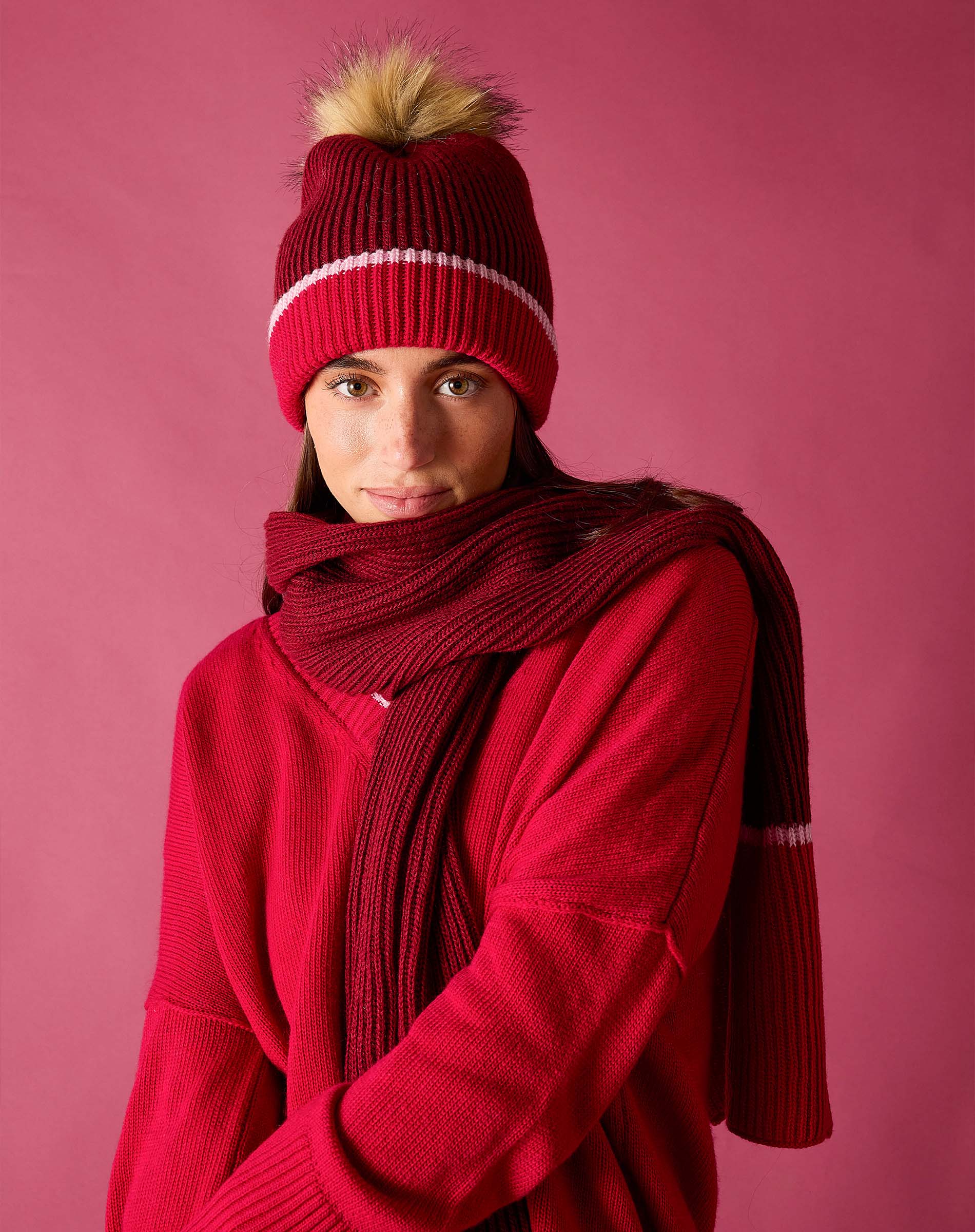 Ladies' travel-ready raspberry pink chunky knit scarf and matching beanie with a pom-pom.