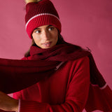 Raspberry pink knit scarf with a striped border.