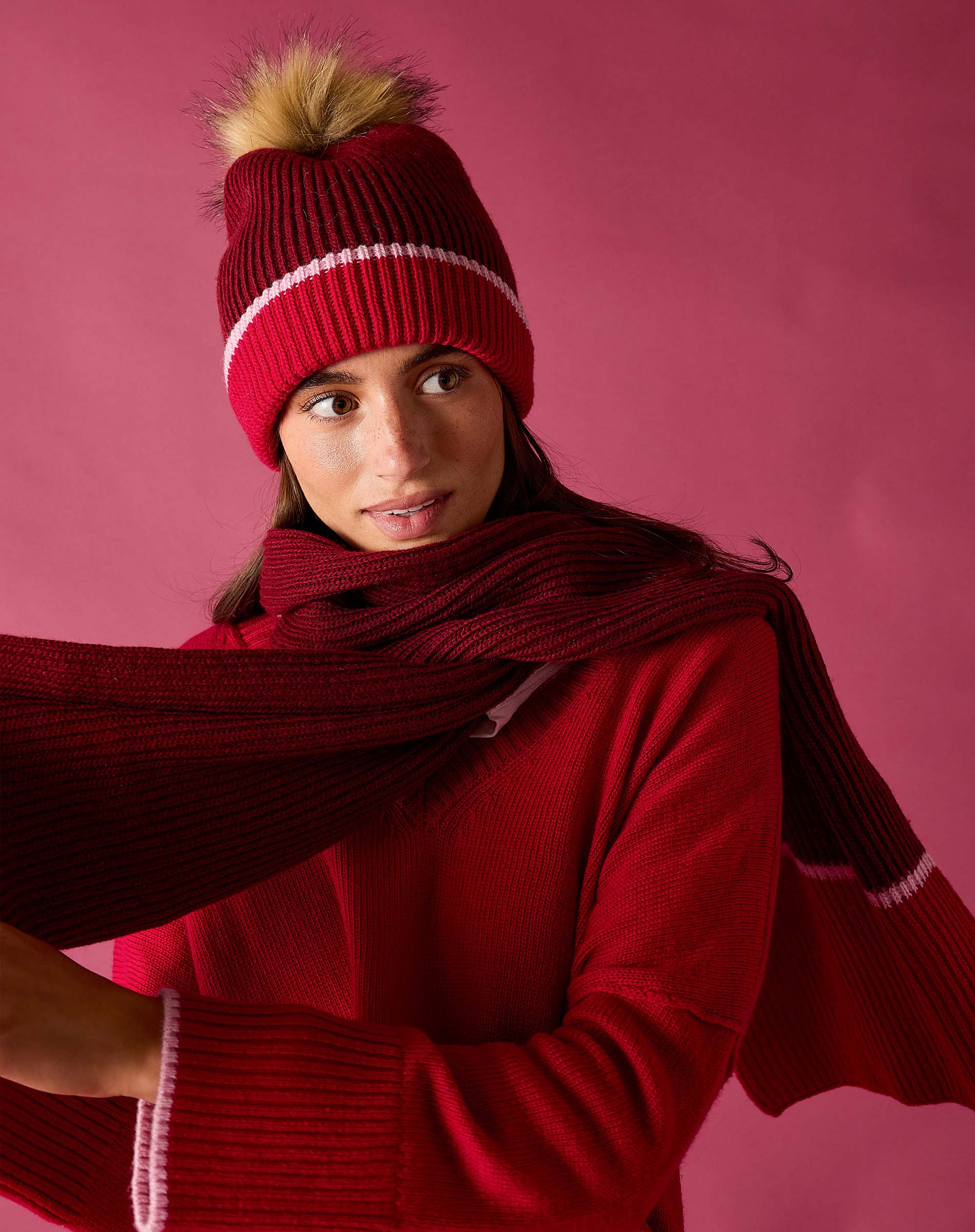 Raspberry pink knit scarf with a striped border.