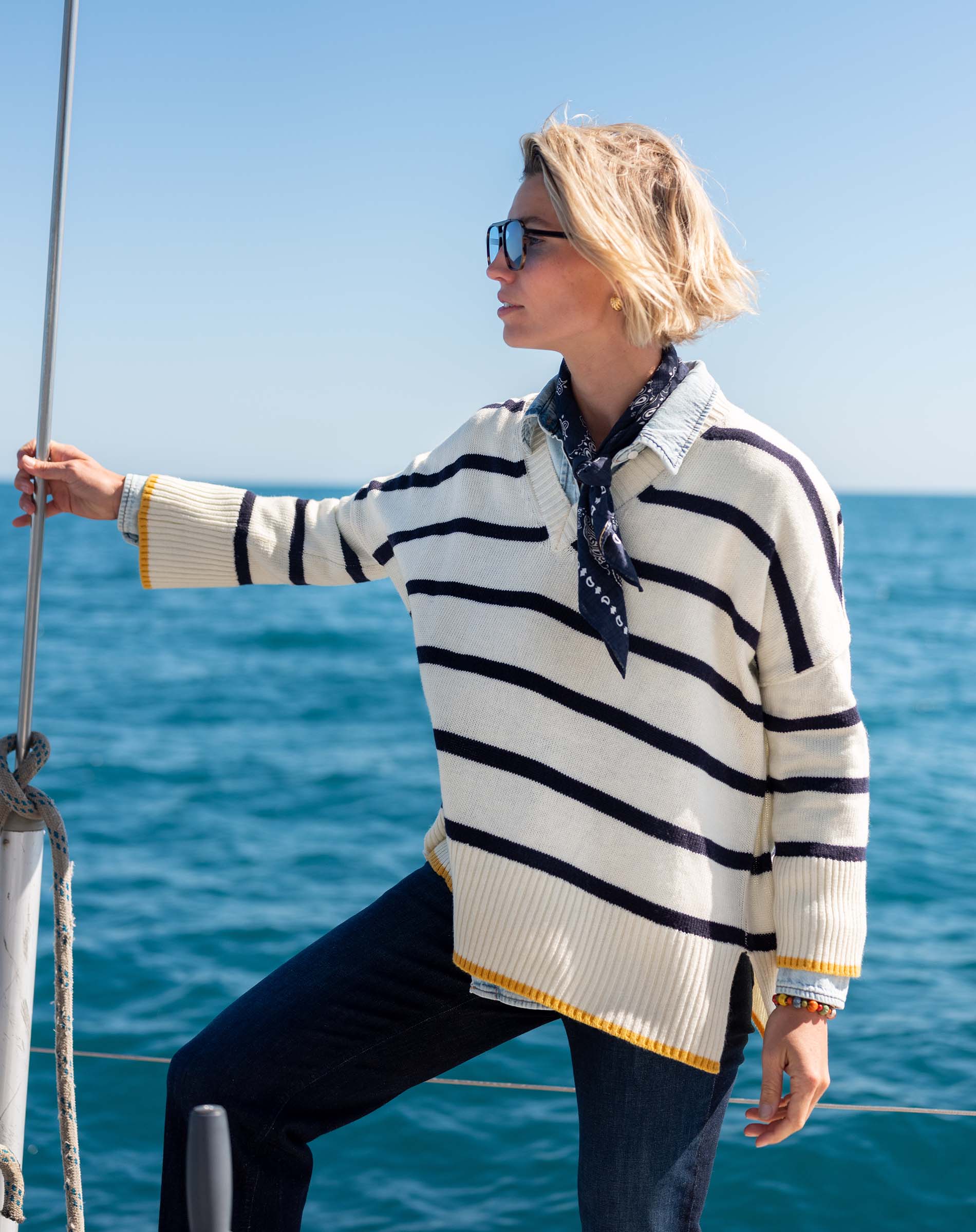 Cream and navy striped knit top with a yellow trim and long sleeves.