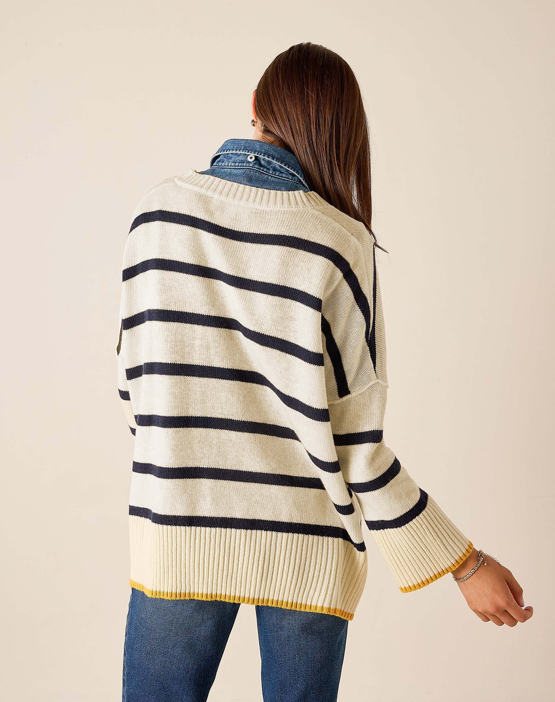 Back view of women's travel-friendly cream and navy striped knit top with golden accents.