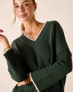 Ladies' travel-ready forest green ribbed knit V-neck sweater with contrast trim.