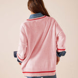 Back view of women's travel-friendly pink and red knit v-neck pullover with a striped hem and contrasting blue denim-style collar detail.