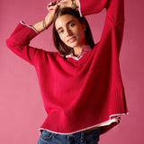 Raspberry pink V-neck knit sweater with a scalloped edge and long sleeves.